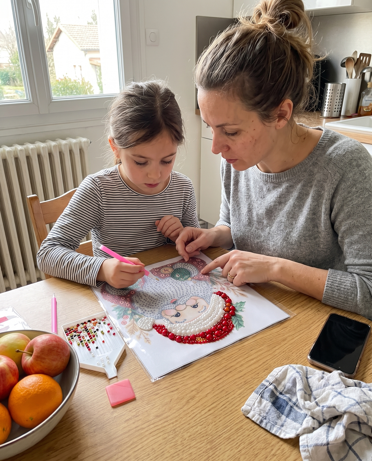 Une maman et sa fille réalisent un tableau de perles dans la cuisine